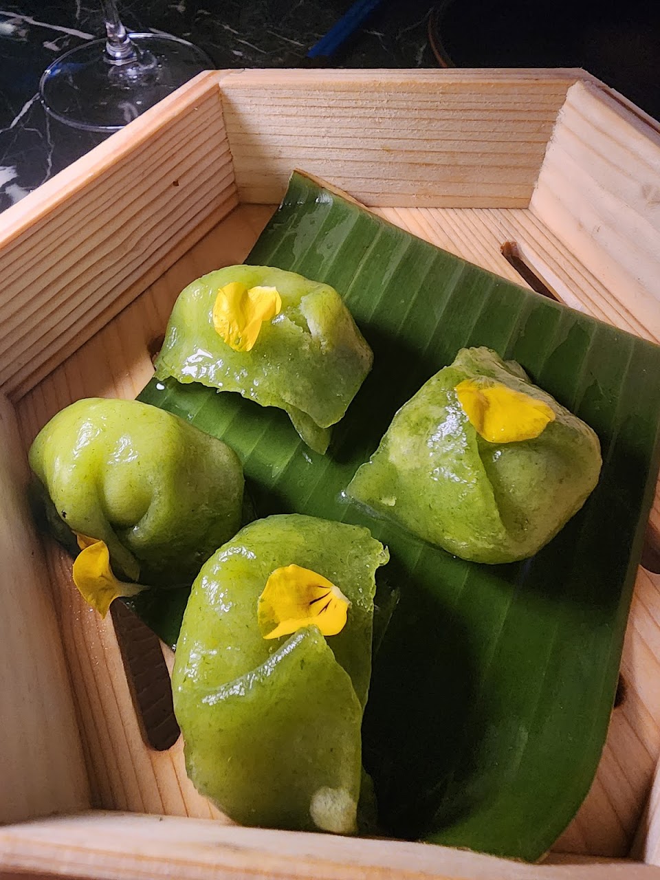 Green dumplings served in a wooden box